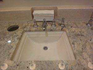 Close-up of sink and marble counter top.