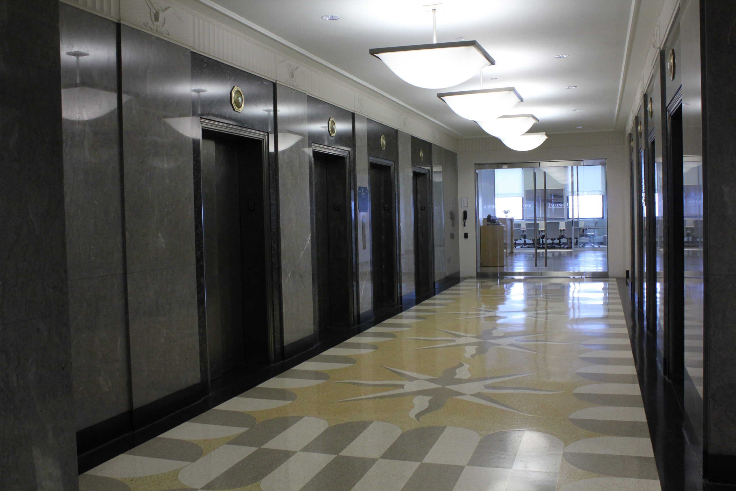 Talisen Construction Corporation: Construction Management and General Contractor. Taconic Management, 111 Eighth Avenue, New York. Custom designed white, gray, and green stone tile with four stone elevator banks work environment