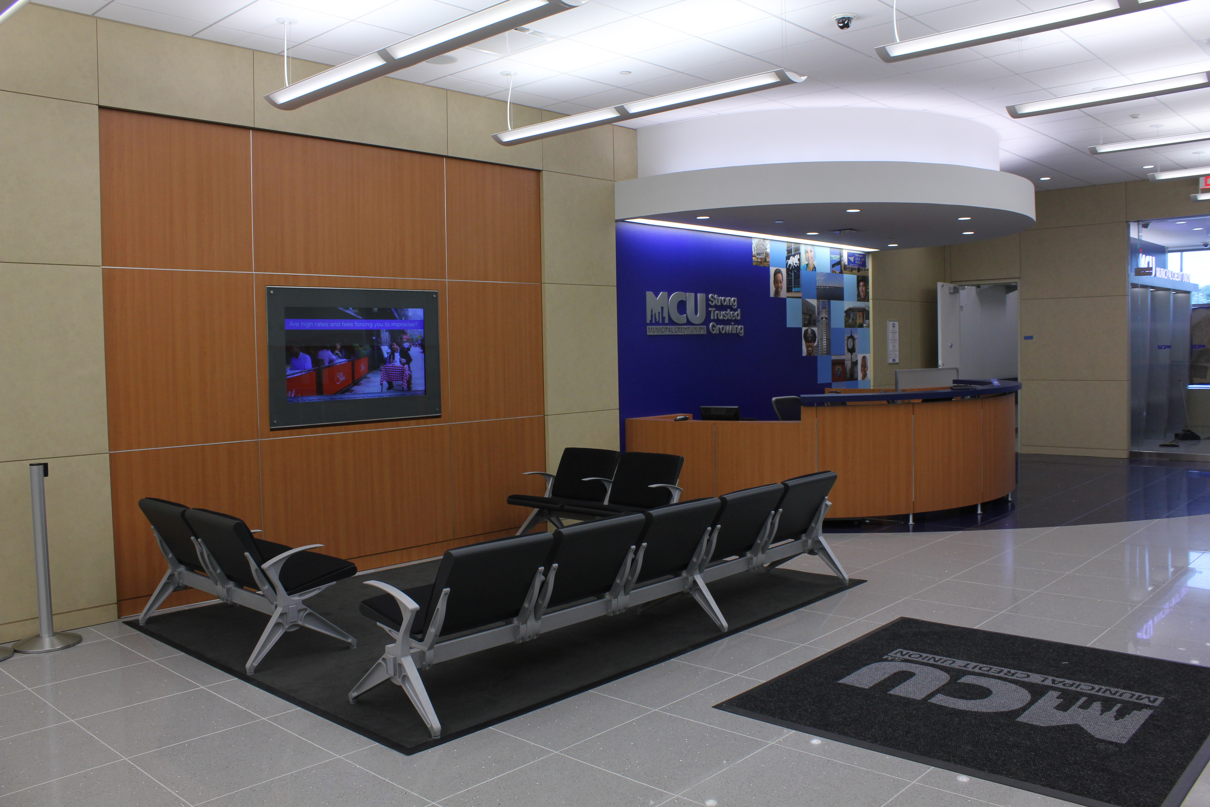 Municipal Credit Union: Talisen Construction Corporation: Construction Management and General Contractor. Municipal Credit Union, 134-66 Springfield Boulevard, Queens: Waiting area with rows of chairs surrounding an in-wall flat screen TV