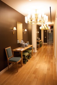 Talisen Construction: Construction Management and General Contractor. Tory Burch, 11 West 19th Street, New York. wood floor lined hallways with candel-like light fixtures and brown walls, one of which is lined with linen wallpaper