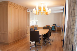 Talisen Construction: Construction Management and General Contractor. Tory Burch, 11 West 19th Street, New York. Executive office with round wooden table and same candle-like fixtures. A custom woodworked cabinet reaches from the floor to the ceiling with wooden radiator covers throughout.