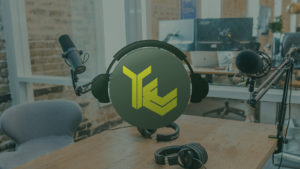 Talisen's logo with headphones on either side. There is a podcast recording studio in the background.