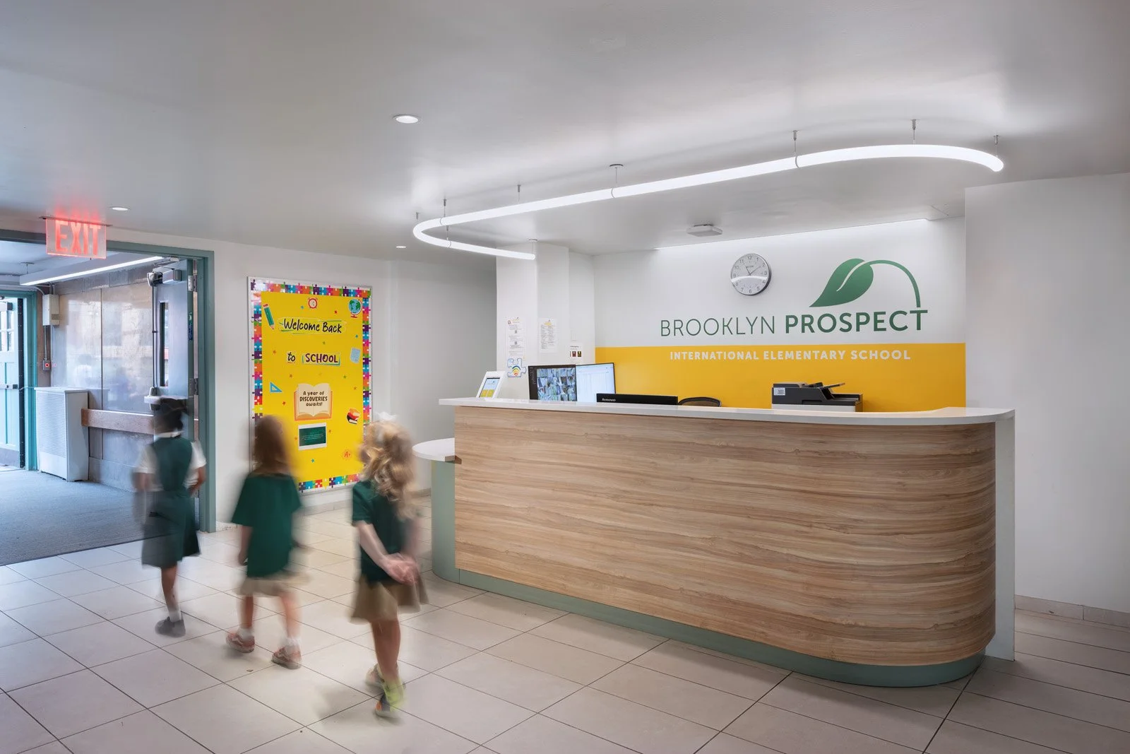 Brooklyn Prospect International Elementary School reception area with signage and students walking past